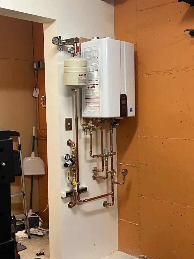 Plumbing technician inspecting water heater connections in Bern